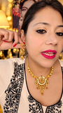 Traditional gold-tone necklace and matching statement earrings worn as a complete set